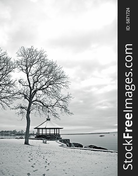 Portrait view of shoreline in winter with gazebo and trees. Portrait view of shoreline in winter with gazebo and trees.