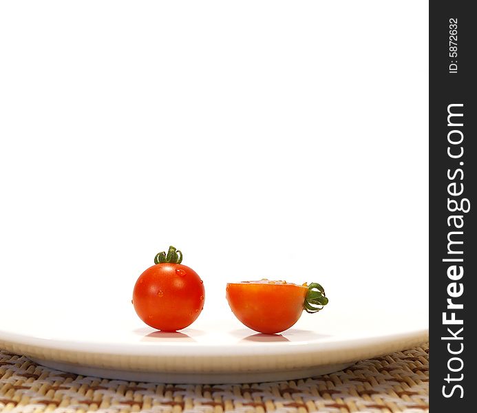 Ripe tomato on a plate isolated on a white background. Ripe tomato on a plate isolated on a white background