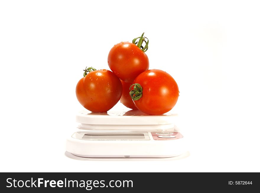 Ripe juicy tomatos and scale isolated on white