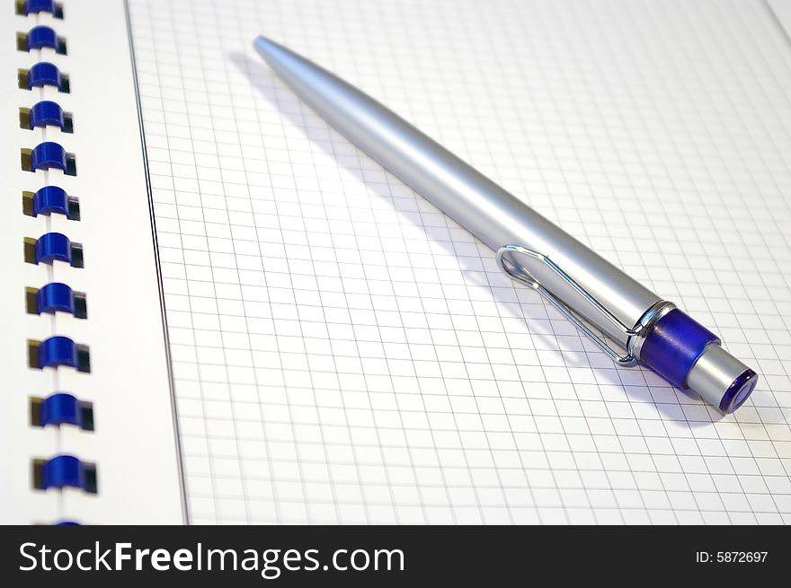 One silver pen and spiral notebook closeup