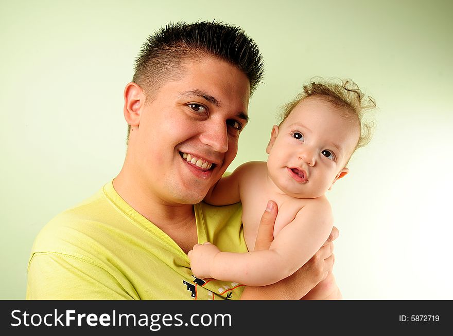 Dad and little baby boy over green background