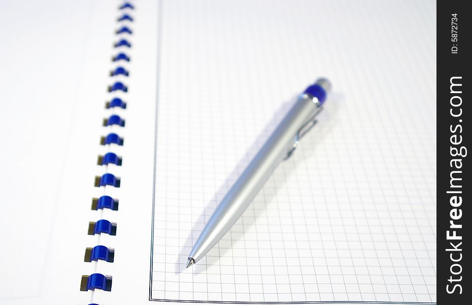 One silver pen and spiral notebook closeup