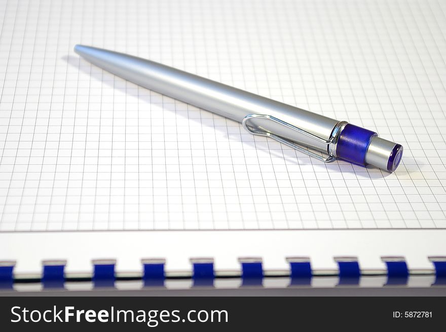 One silver pen and spiral notebook closeup