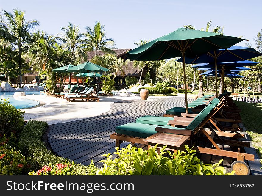 View of an area around swimming pool at a beach resort. View of an area around swimming pool at a beach resort