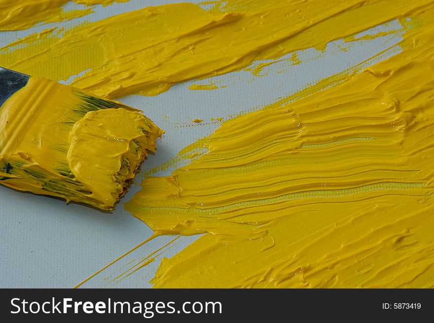 Yellow color on a brush, art painter studio