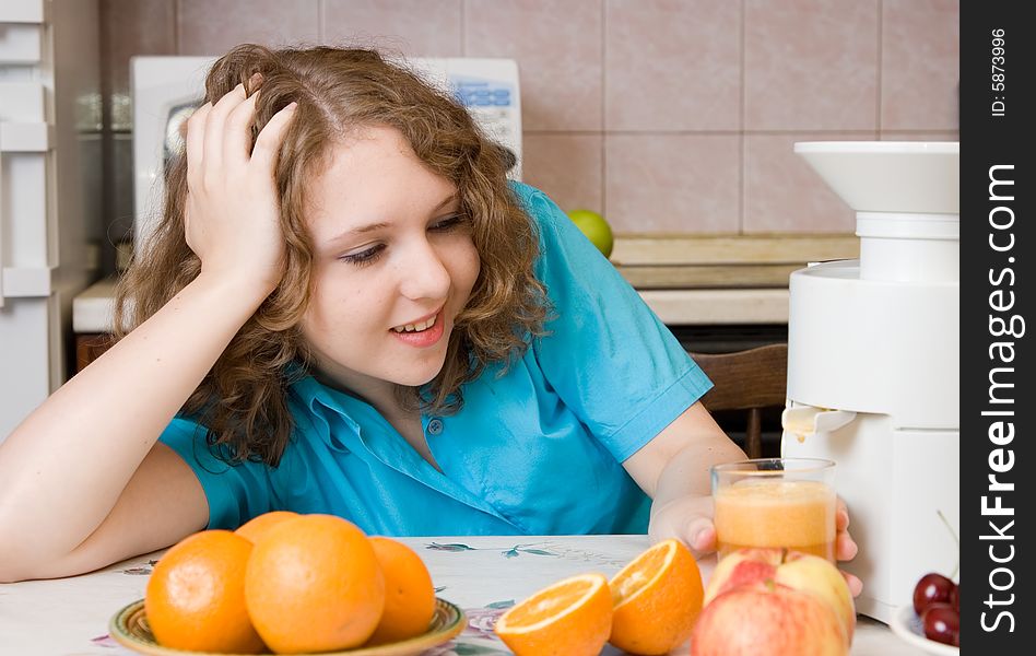 Smiling girl with blender and fruits on home kitchen