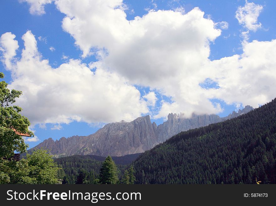 Sella mountain group  on blue cloudy sky, green valley and forest. Italy. Sella mountain group  on blue cloudy sky, green valley and forest. Italy