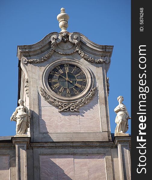 Ancient tower hours on an old palace on a background of the dark blue sky