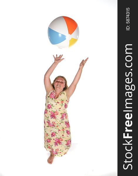 Heavy set girl in dress catching a beach ball. Heavy set girl in dress catching a beach ball