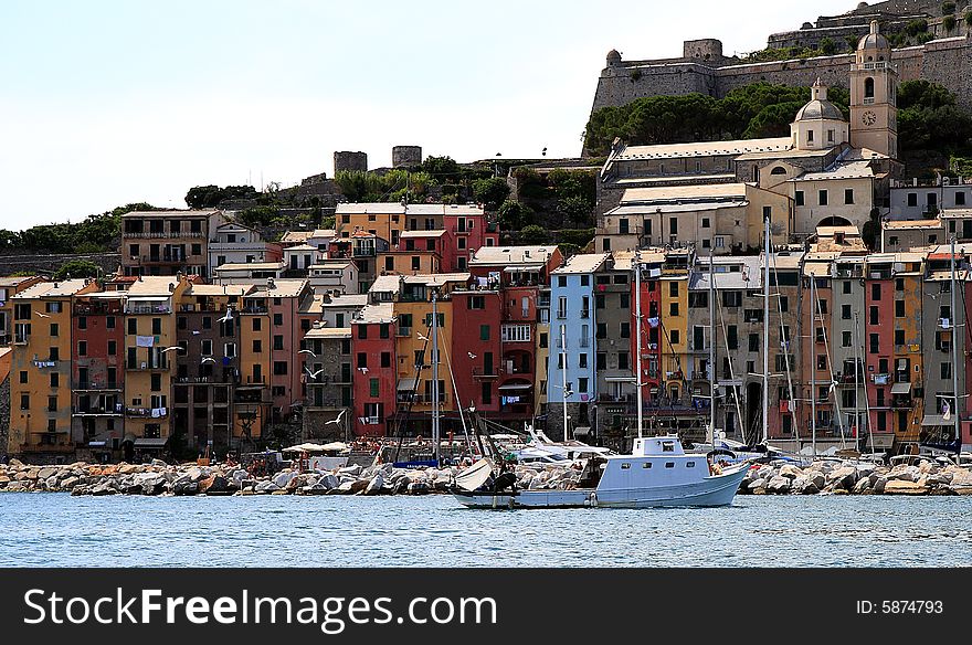 Fishing boats on a harbor with the seafront view of Portovenere in Italy.