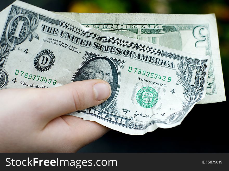 Six dollars in United States currency held in the right hand. Six dollars in United States currency held in the right hand.