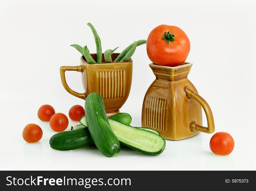 Composition from cucumbers, tomatoes and a siliculose string bean in ceramic cups. Composition from cucumbers, tomatoes and a siliculose string bean in ceramic cups