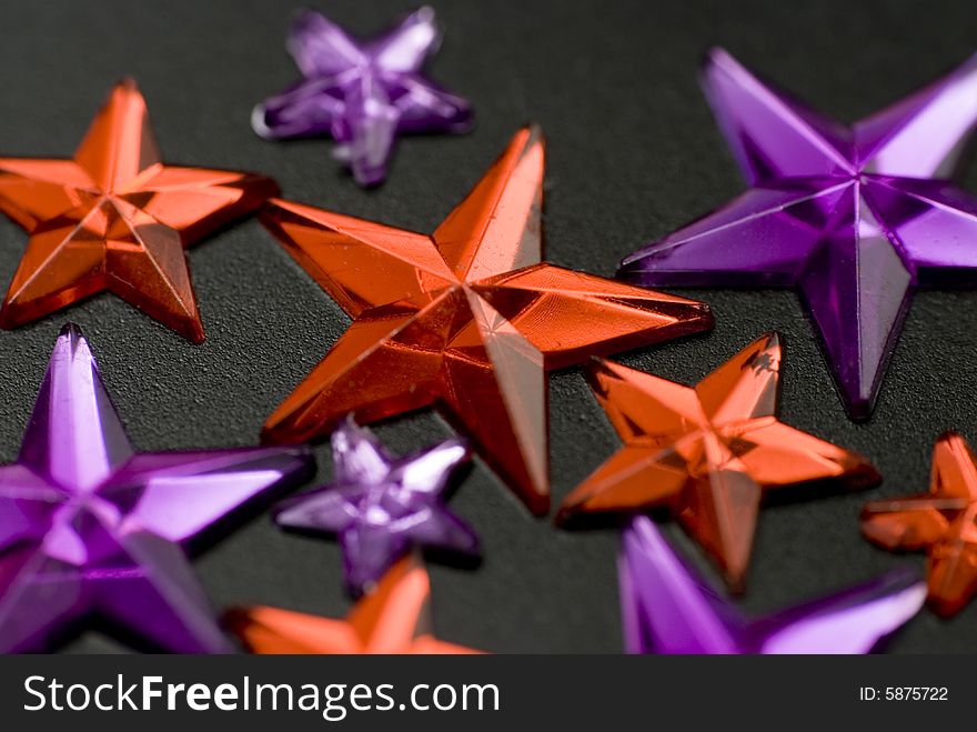 Red and purple christmas stars on black background