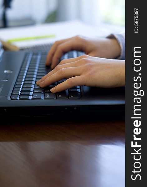 Profile view of hands typing on a black keyboard. Profile view of hands typing on a black keyboard.