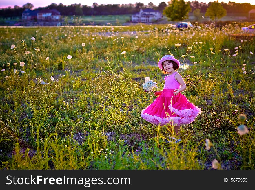 Child in a flower field wearing a cute pettiskirt and rose pink hat