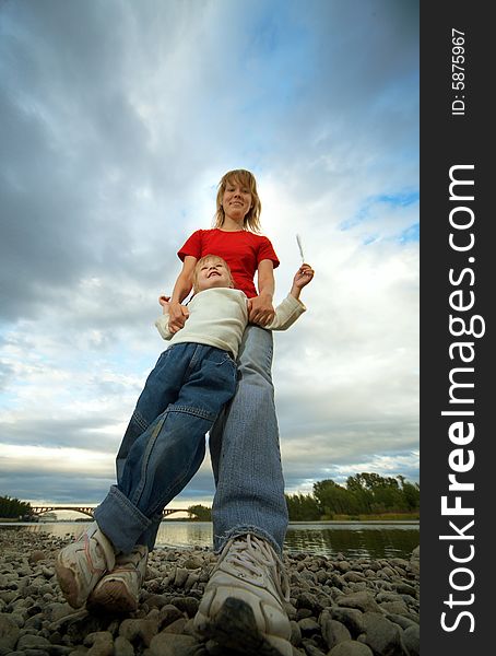 Mother and child outdoor on stones and river