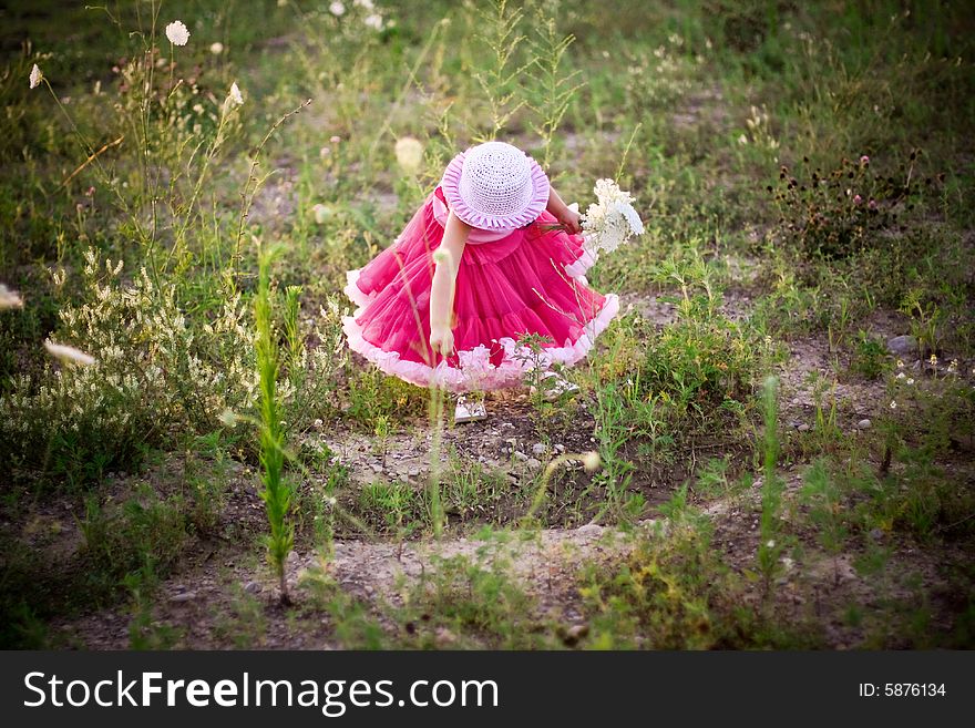 Child in a flower field wearing a cute pettiskirt and rose pink hat