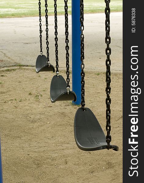 Motionless swings on a sandy playground. Motionless swings on a sandy playground.