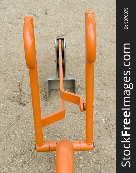 A close up of an orange and silver toy bulldozer in a sandbox. A close up of an orange and silver toy bulldozer in a sandbox.