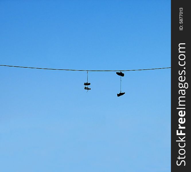 Hanging shoes over an electric line.