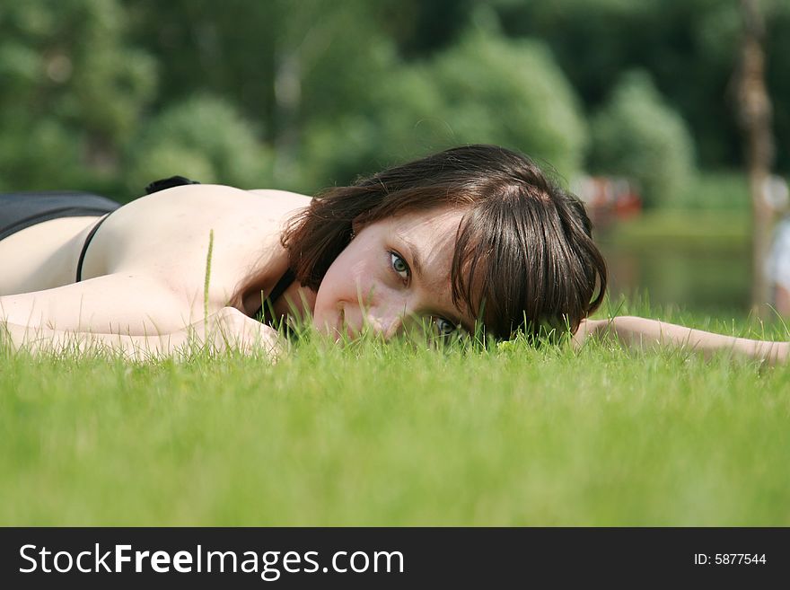 Portrait of the girl laying on a grass in a sunny day. Portrait of the girl laying on a grass in a sunny day