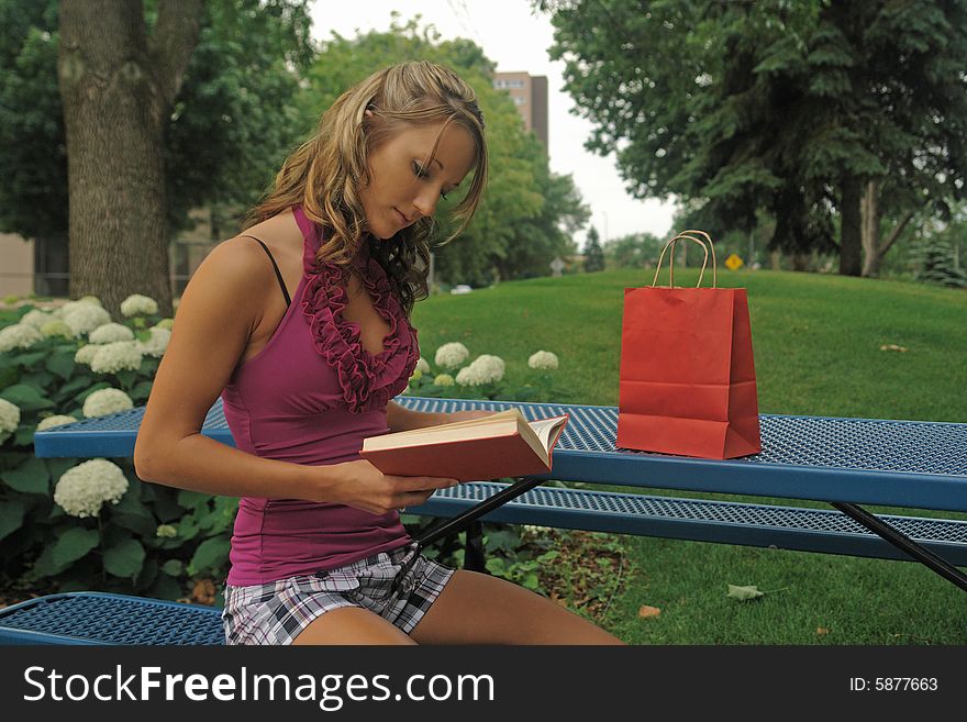 A picture of a woman reading  a book in the park. A picture of a woman reading  a book in the park