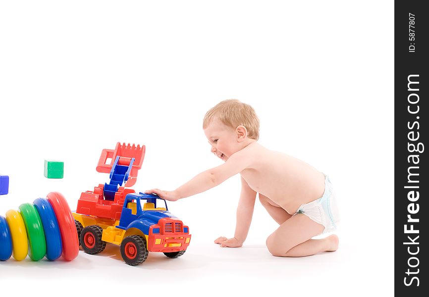 Little boys play with toy truck over white background with light shadows.