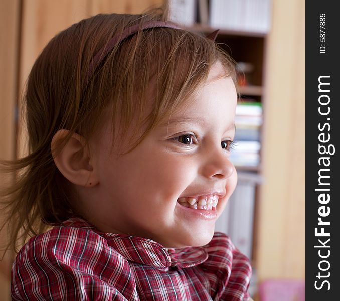 Portrait of a joyful little girl in living room