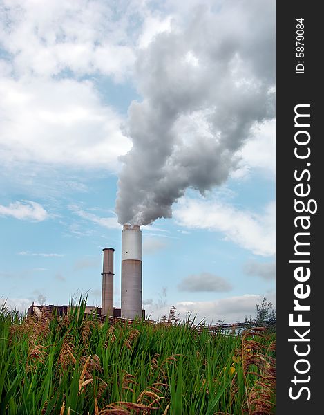 Smoke billowing out of the large smoke stack at a power plant. Smoke billowing out of the large smoke stack at a power plant.