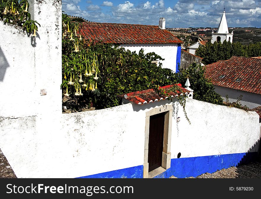 Portugal, Obidos situated in the district of Leiria is a small medieval fortified city well preserved turned into a tourist attraction. View of the typical white houses and narrow streets. Portugal, Obidos situated in the district of Leiria is a small medieval fortified city well preserved turned into a tourist attraction. View of the typical white houses and narrow streets