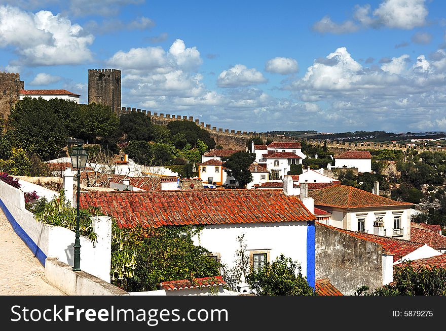 Portugal, Obidos situated in the district of Leiria is a small medieval fortified city well preserved turned into a tourist attraction. View of the typical white houses and narrow streets. Portugal, Obidos situated in the district of Leiria is a small medieval fortified city well preserved turned into a tourist attraction. View of the typical white houses and narrow streets