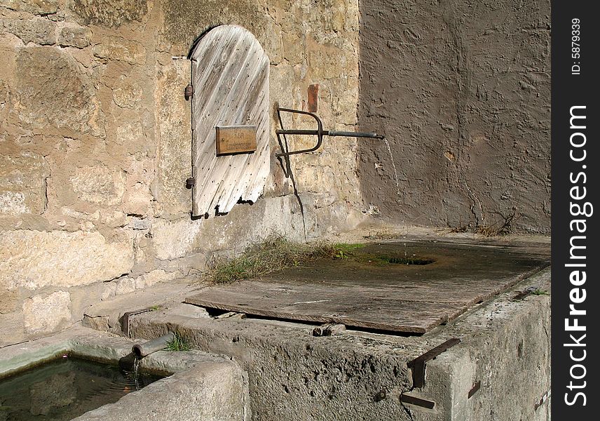 Ancient artesian spring, coming out of an old pipe in the thick walls of this venerable fortress city, in central Germany, in late October. Ancient artesian spring, coming out of an old pipe in the thick walls of this venerable fortress city, in central Germany, in late October.