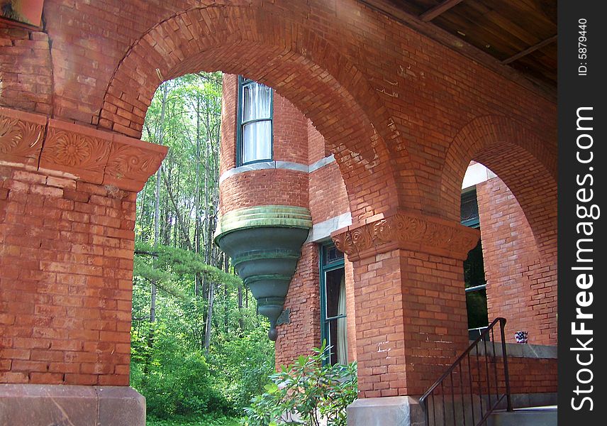 A beautiful brick building with arches and detail and amazing carvings and a wonderful window.