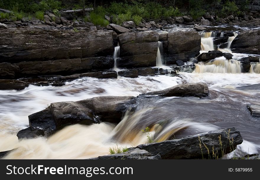 Water rushing down steps into the rapids of a raging river. Water rushing down steps into the rapids of a raging river.