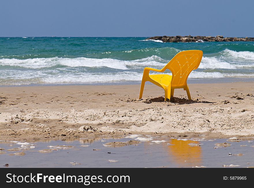 A lonely yellow chair standing on sea beach. A lonely yellow chair standing on sea beach