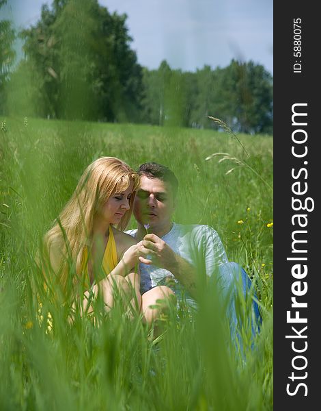 Attractive couple together on meadow in summer day