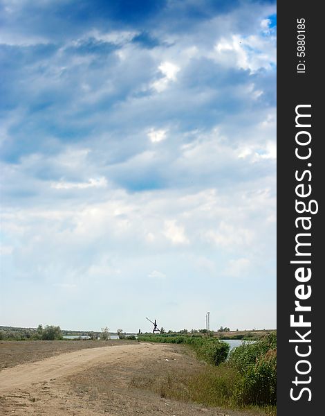 Rural road on background year blue sky and clouds