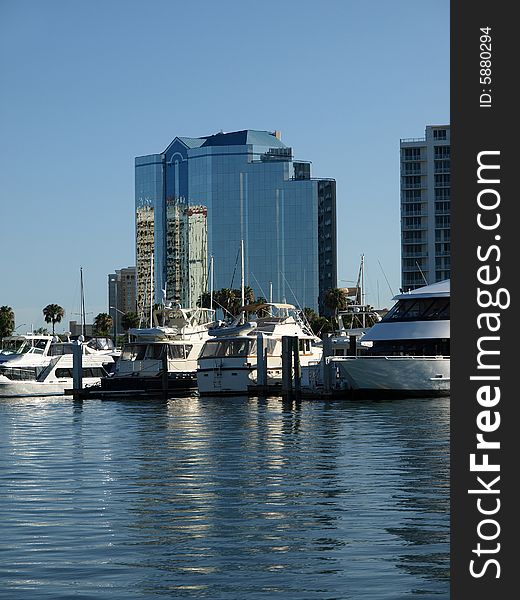Luxury Glass Hotel with Yachts in Harbor blue sky and water
