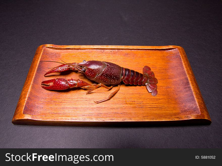 Seafood crawdads with covering in a wooden plate.