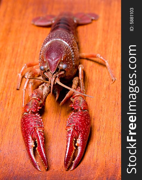 Seafood crawdads with shells in a wooden plate.