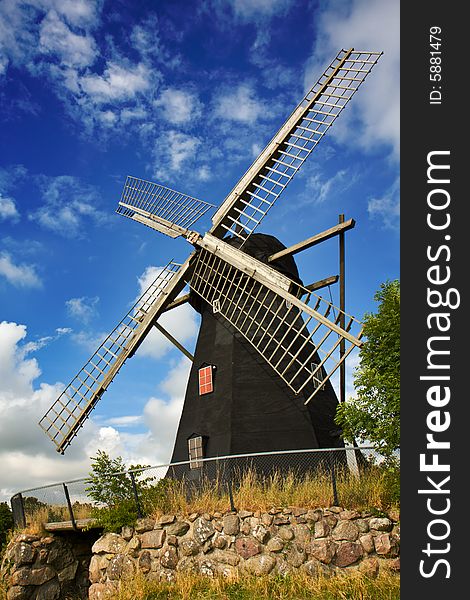 Traditional windmill with cloudy blue skye (Sweden).