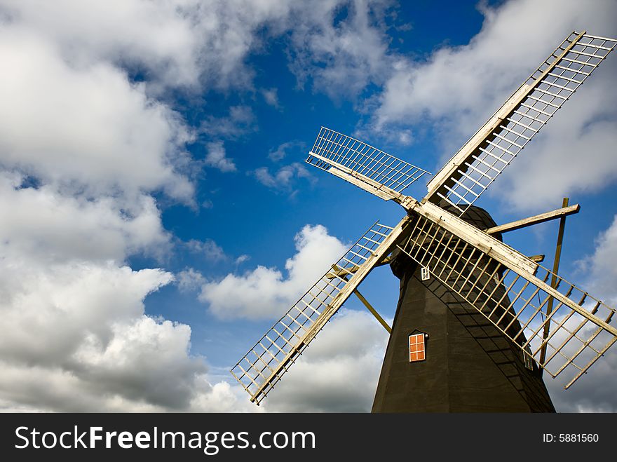 Traditional windmill with cloudy blue skye (Sweden).