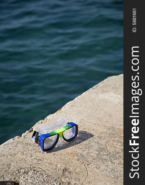 A goggles on a ronck close to the sea