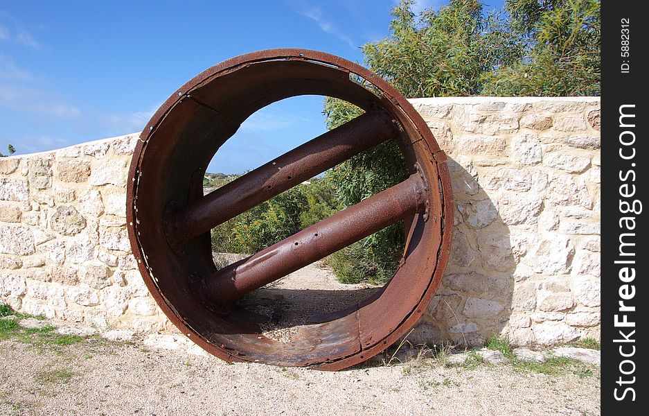 Juxtaposition of a modern stone wall built around a rusty old cylindrical mining object, in the Innes National Park, Yorke Peninsula, South Australia. Juxtaposition of a modern stone wall built around a rusty old cylindrical mining object, in the Innes National Park, Yorke Peninsula, South Australia.