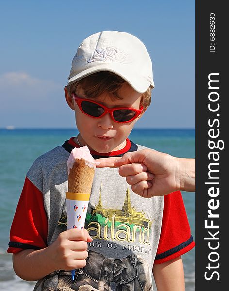 On seacoast the boy eats ice cream