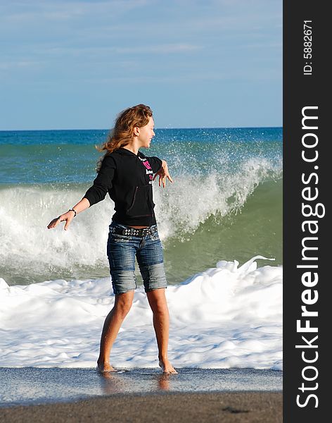 Joyful girl play on coast of ocean