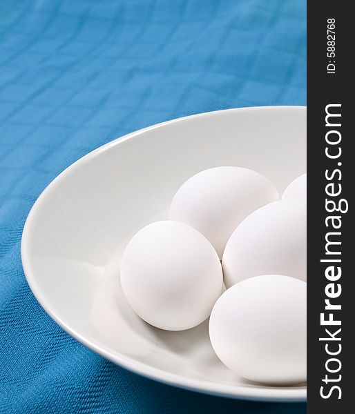 Eggs in white bowl with a colorful background. Eggs in white bowl with a colorful background