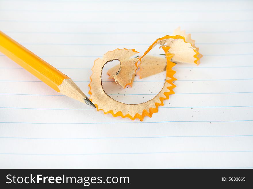 Pencil with shavings after being sharpened on a piece of notebook paper. Pencil with shavings after being sharpened on a piece of notebook paper.