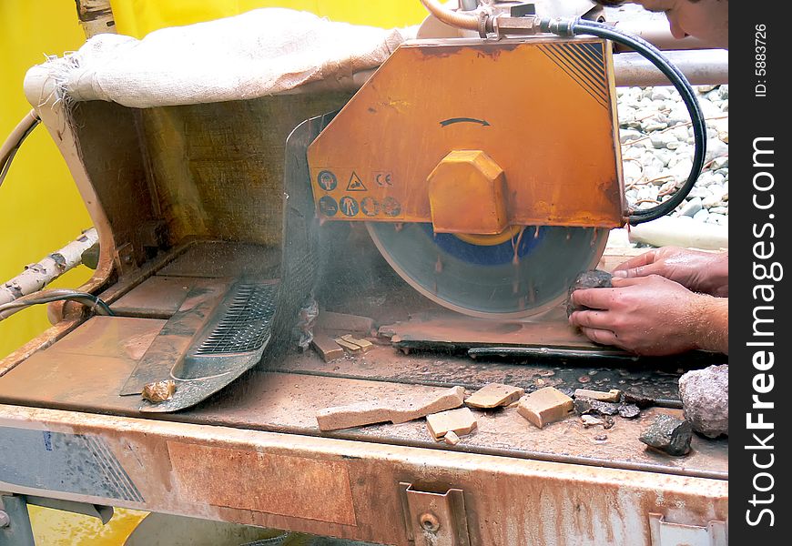 Close up of the man's hands at work. Cutting of stones on the circular saw. Close up of the man's hands at work. Cutting of stones on the circular saw.