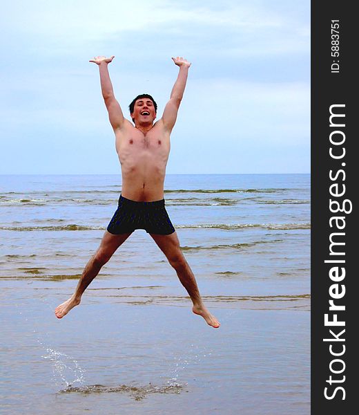 Man jumping on seacoast.